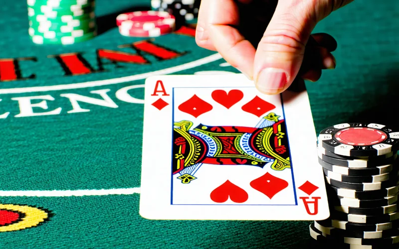 Tay nhà cái trong trò Xì Dách với các lá bài lật ngửa và úp, thể hiện sự hồi hộp của trò chơi