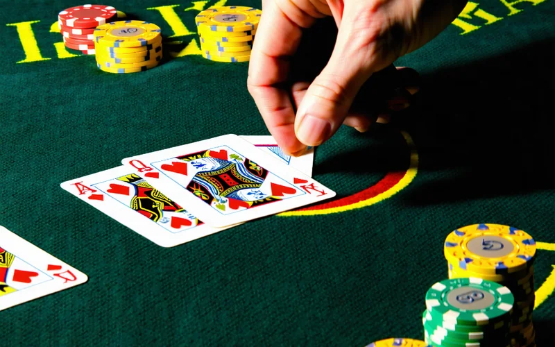 Một người chơi Xì Dách đang phân tích kỹ lưỡng các lá bài trên tay mình, thể hiện sự tập trung vào chiến lược